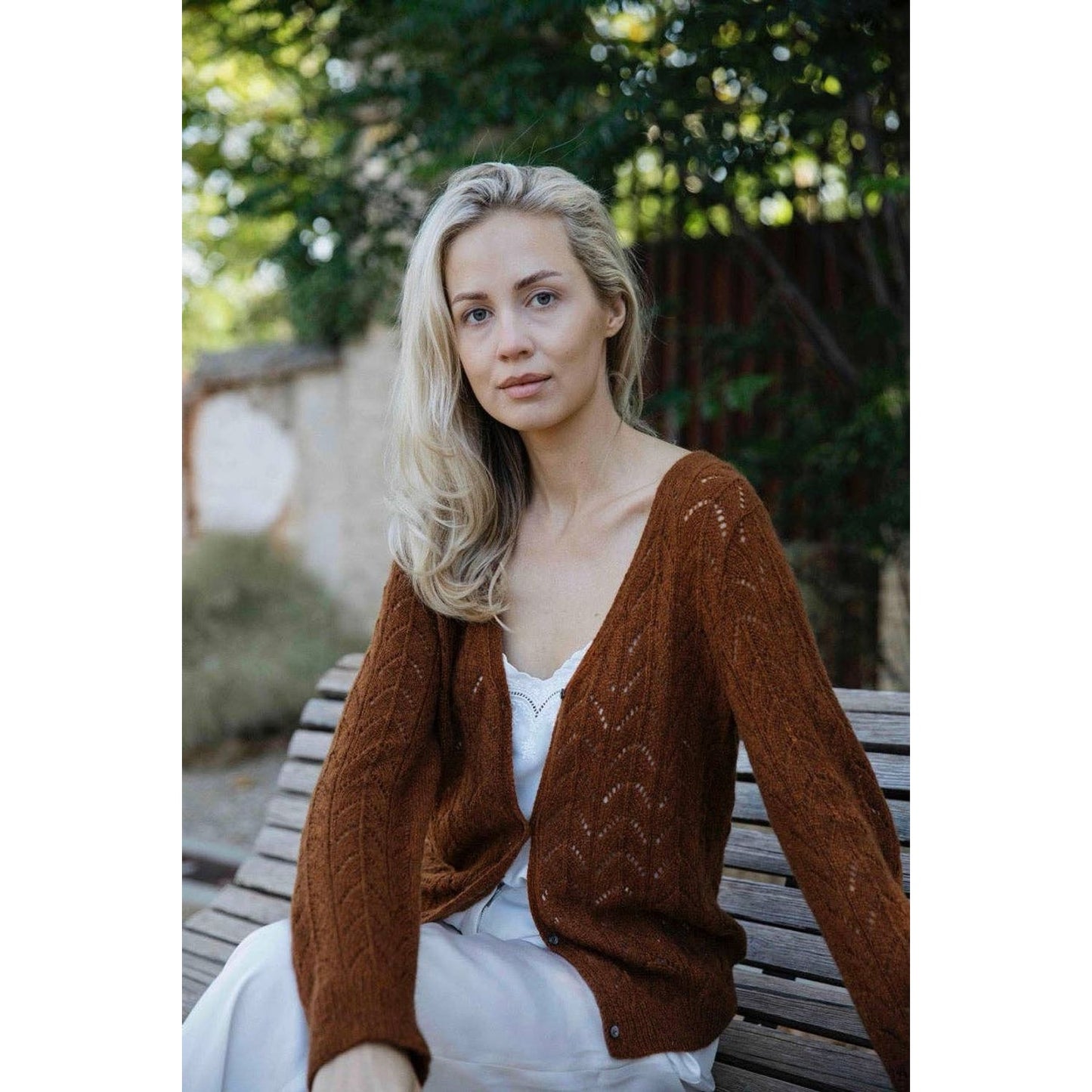 Model wearing a cozy brown cardigan inspired by the Memory Lane knitting book from Laine Publishing