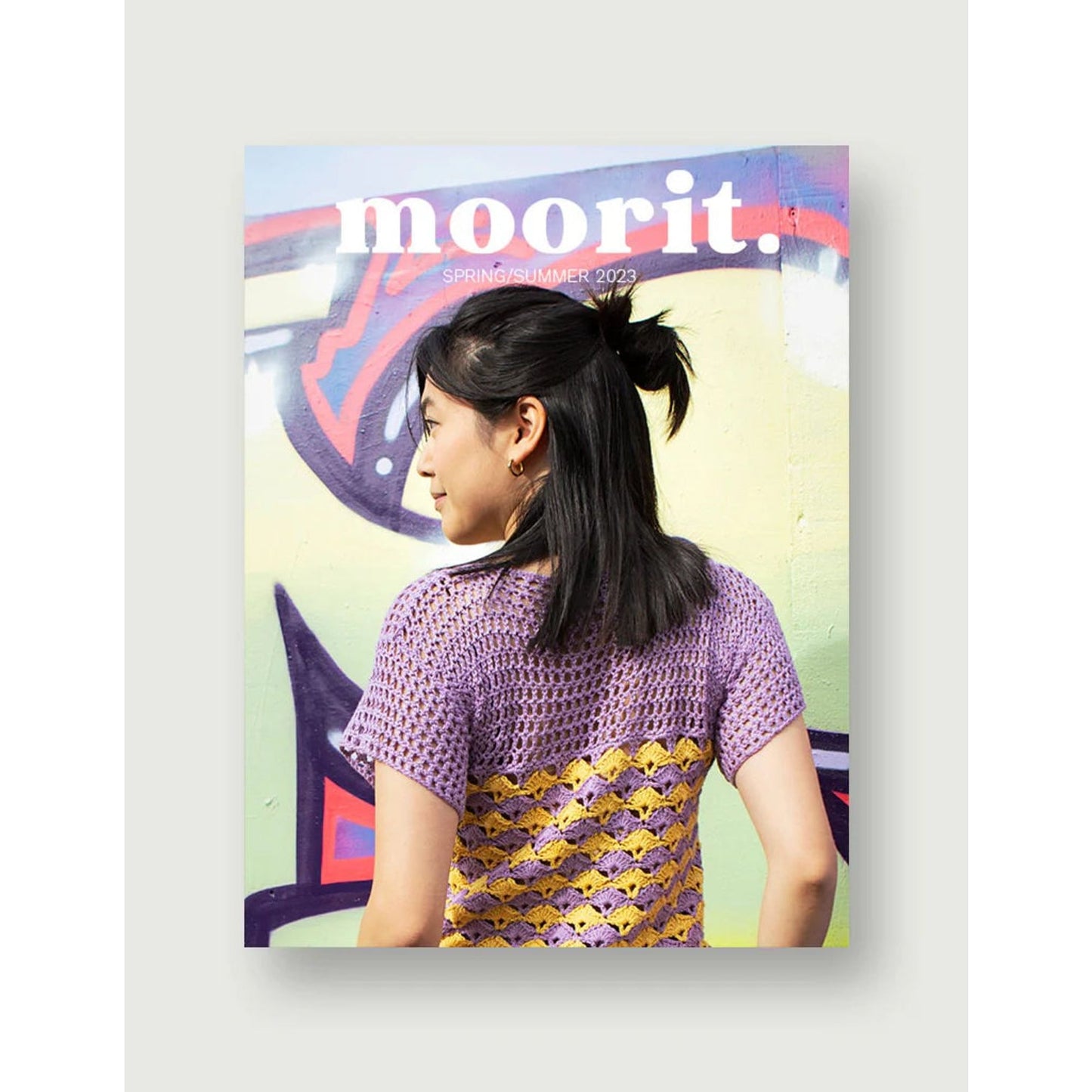 Moorit Magazine crochet patterns cover showing woman in purple and yellow crochet top against a graffiti wall