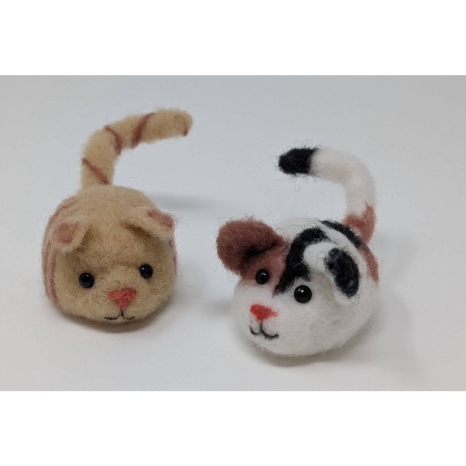 Two adorable needle felted cat figures in tan and black and white, ideal for needle felting needles projects