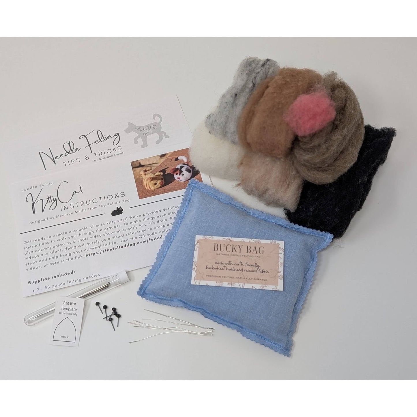 Needle felting supplies including wool roving, needle felting needles, and instructional materials