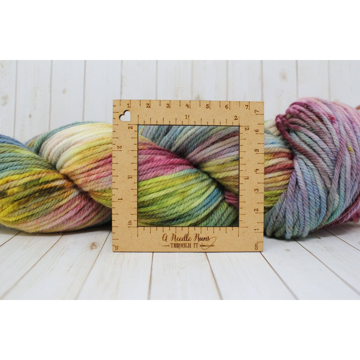 Multi-colored yarn for knitting a gauge swatch with a wooden ruler frame