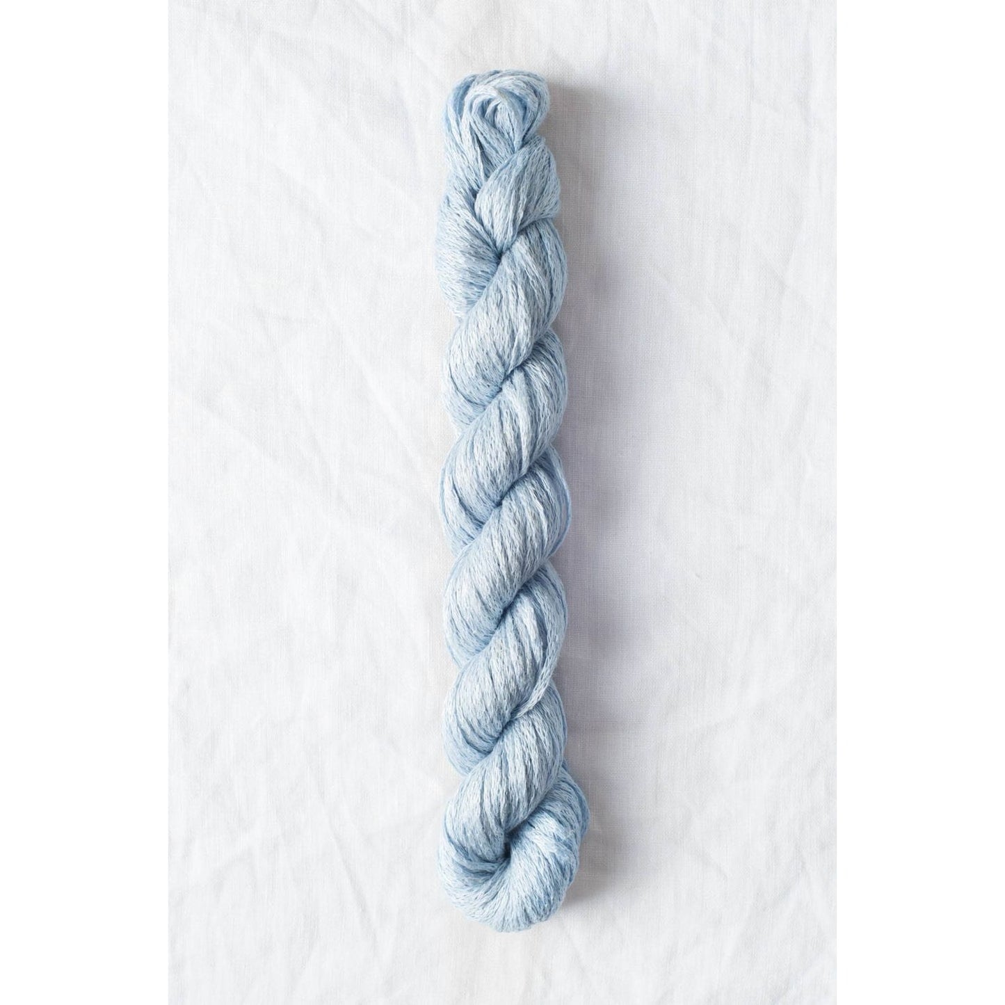Light blue Quince & Co. organic Italian yarn in a twisted skein for knitting and crocheting projects