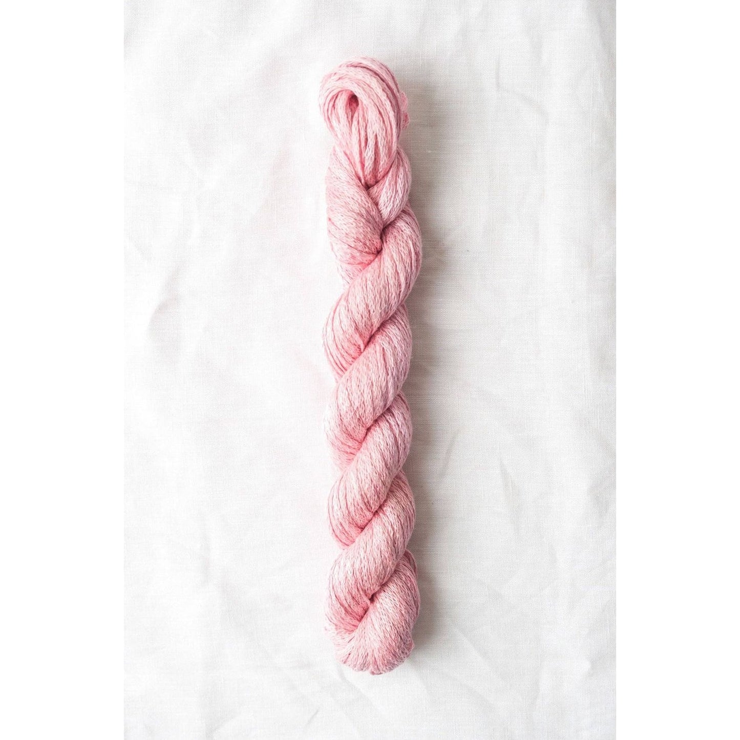 Soft pink Quince & Co. organic Italian yarn in a twisted skein for knitting and crochet projects