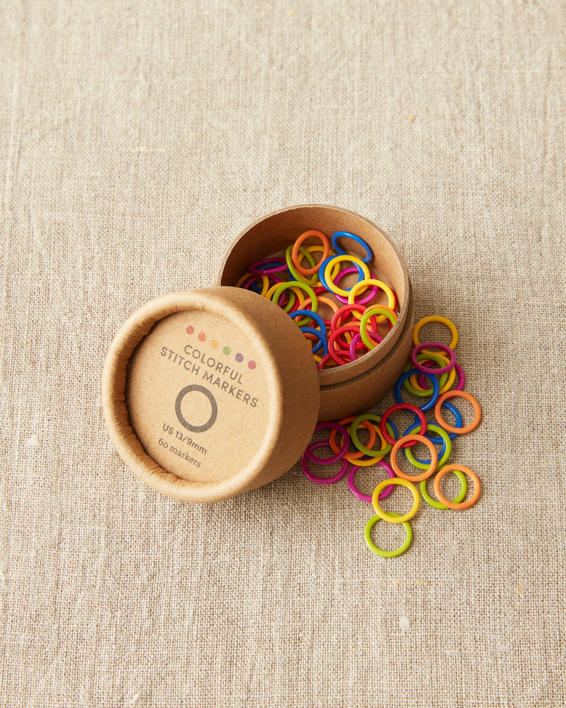 Cocoknits original stitch markers for knitting in various bright colors in a round brown container