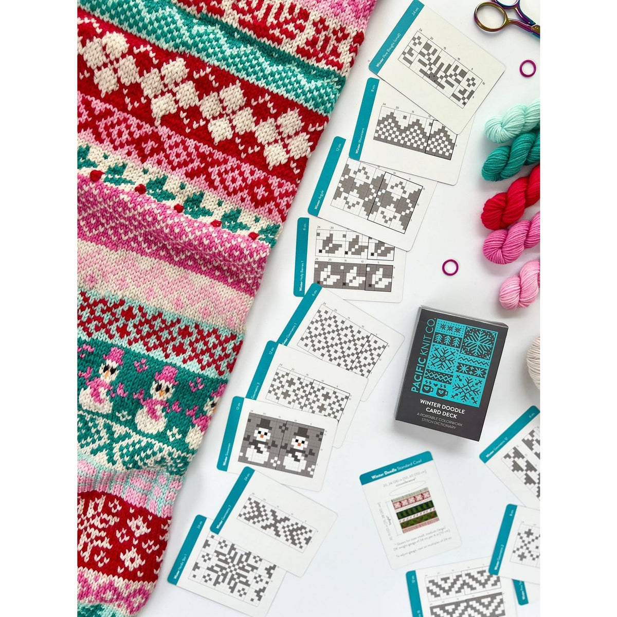 Colorful collection featuring a cozy sweater, yarn, and a deck of card for knitters with unique patterns