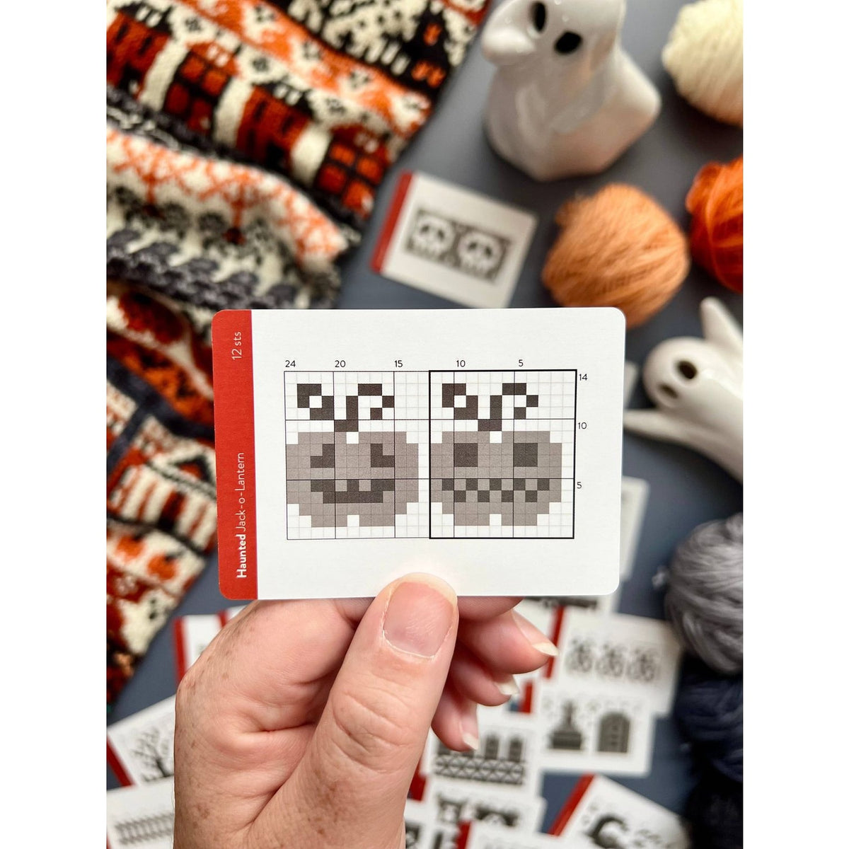 Hand holding a knitting pattern card featuring a pumpkin design from a deck of card by Twice Sheared Sheep
