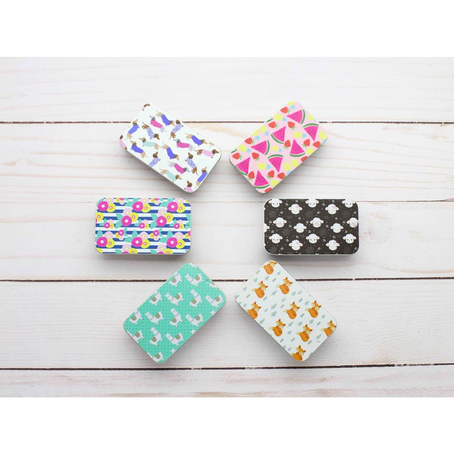 Set of colorful print slide top storage tins featuring various fun and playful designs