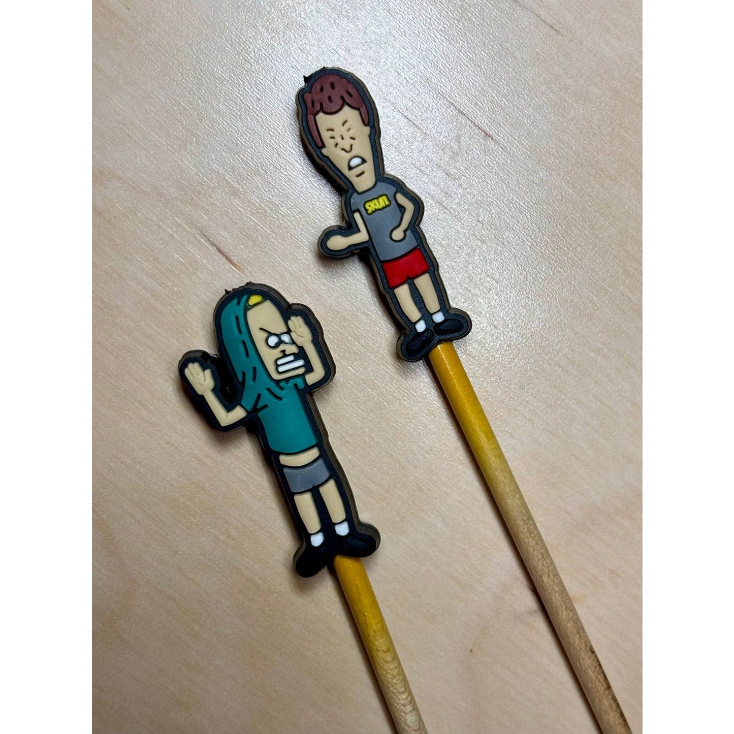 Set of two 90s cartoon knitting needle point protectors on wooden needles for stitch safety and retro craft style