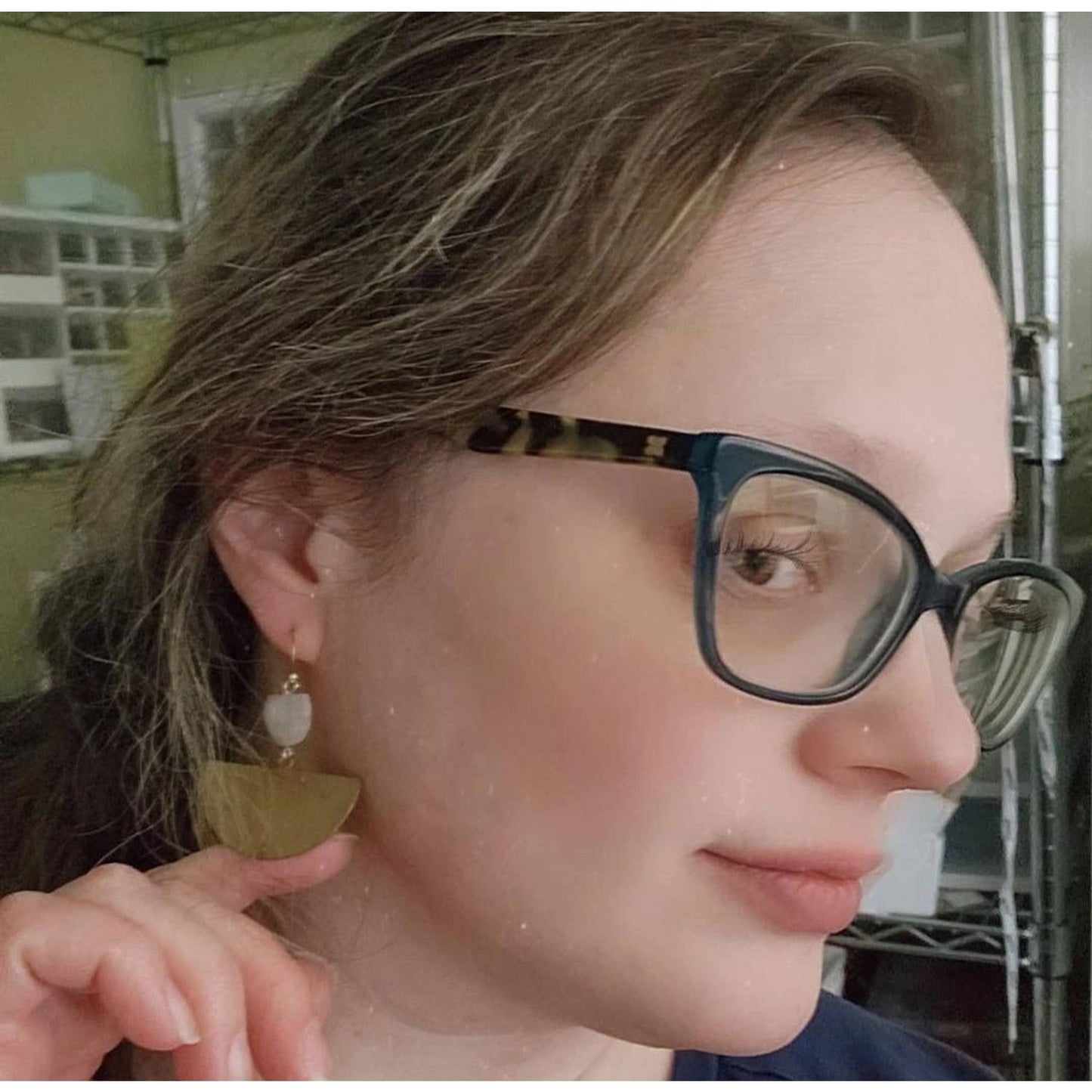 Woman wearing Sara Sela Jewelry crescent rainbow moonstone earrings closeup gold crescent and moonstone bead
