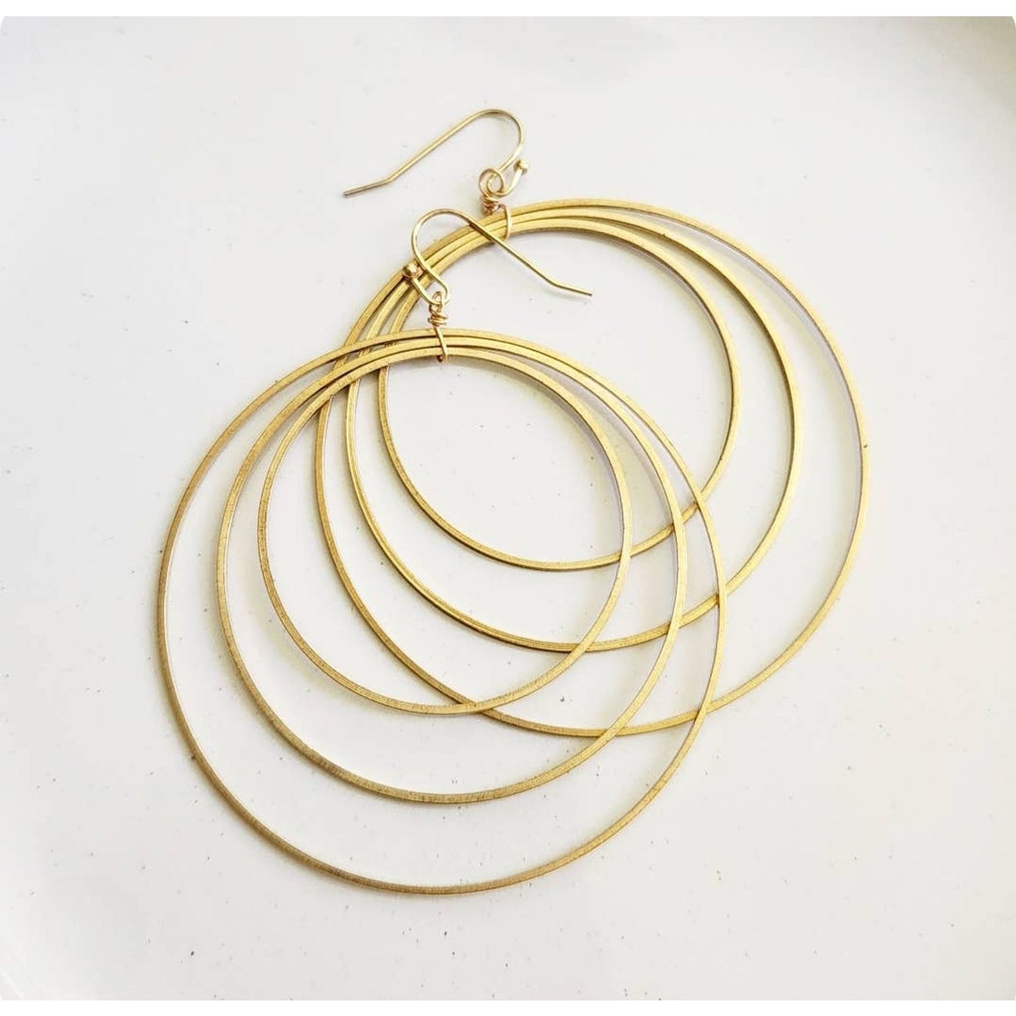 Sara Sela Jewelry brass circle hoop dangle earrings pair of layered thin concentric gold hoops with fishhook wires