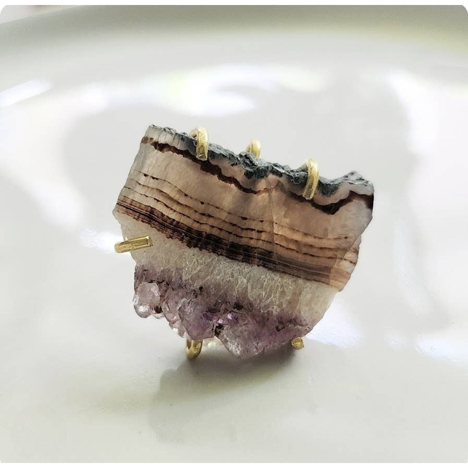 Sara Sela jewelry amethyst ring raw banded amethyst slice set in gold prong ring on white dish