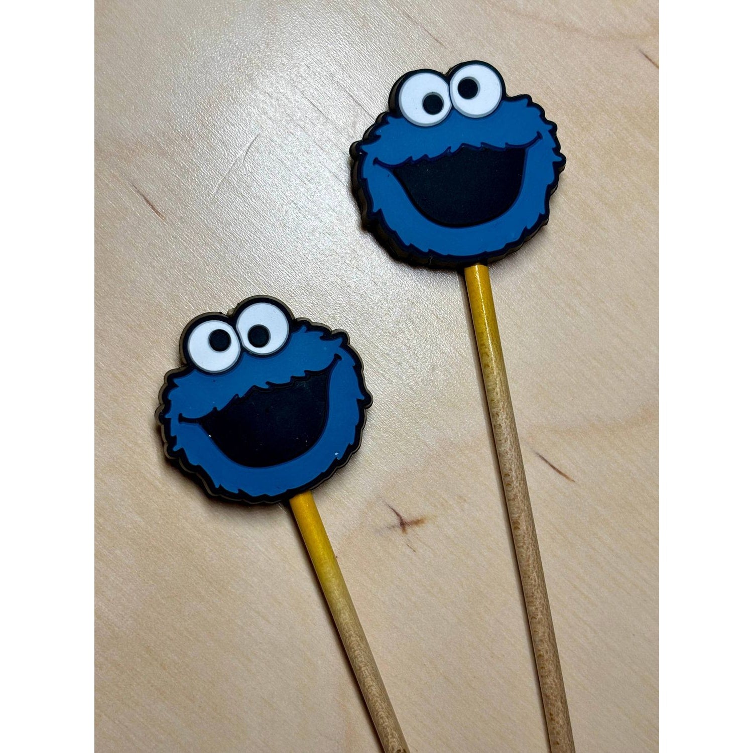 Pair of Cookie Monster knitting needle point protectors on wooden needles by Comma Craft Co to protect stitches
