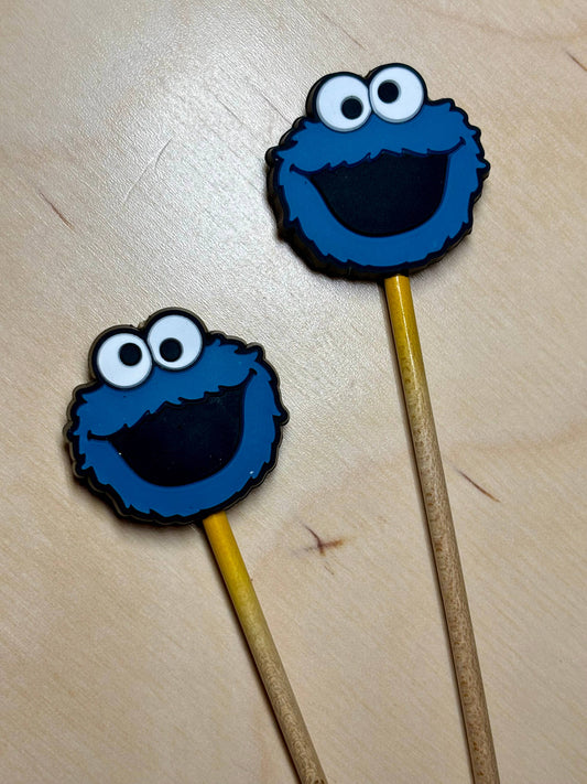 Pair of Cookie Monster knitting needle point protectors on wooden needles by Comma Craft Co to protect stitches