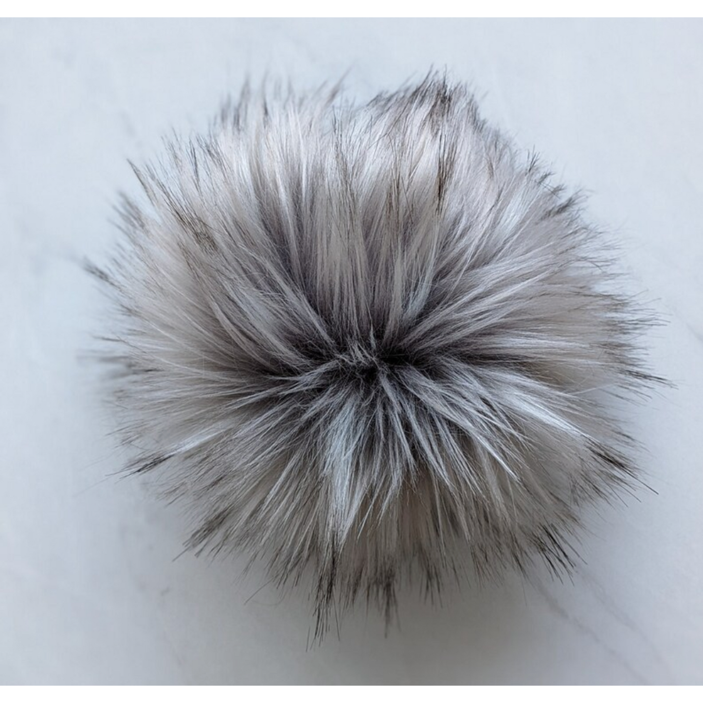 Fluffy silver grey pom pom for knitting, perfect for adding texture to hats and crafts