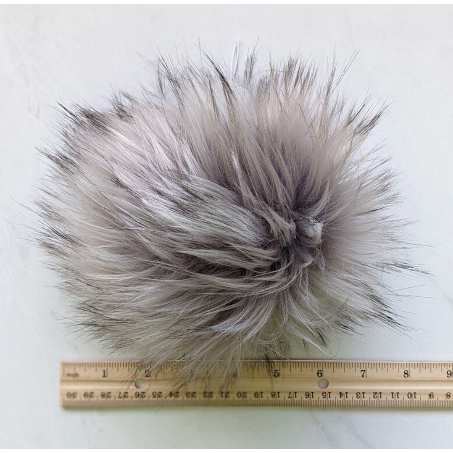 Soft silver grey pom pom for knitting with fluffy texture for creative projects