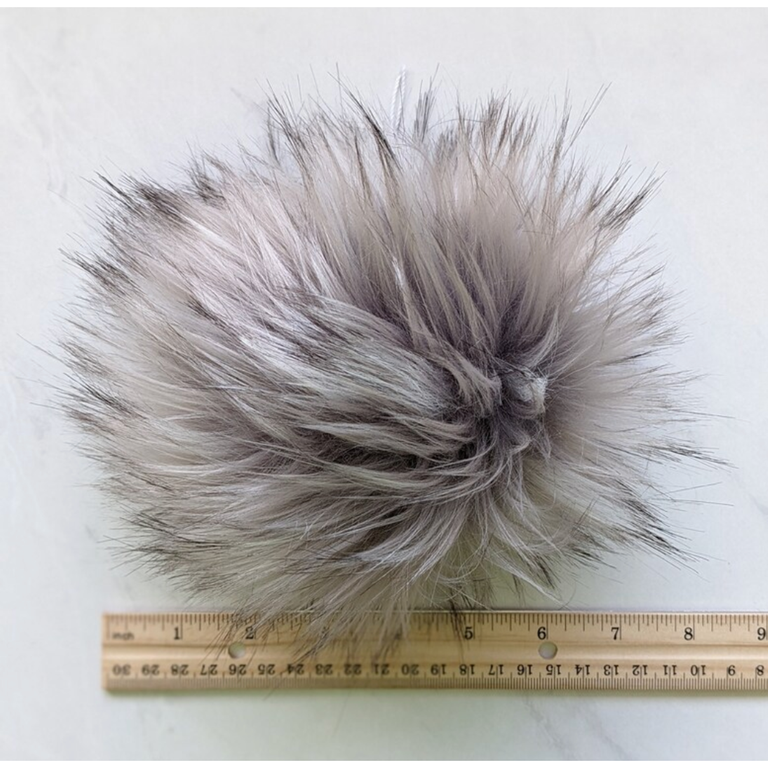 Soft silver grey pom pom for knitting with fluffy texture for creative projects