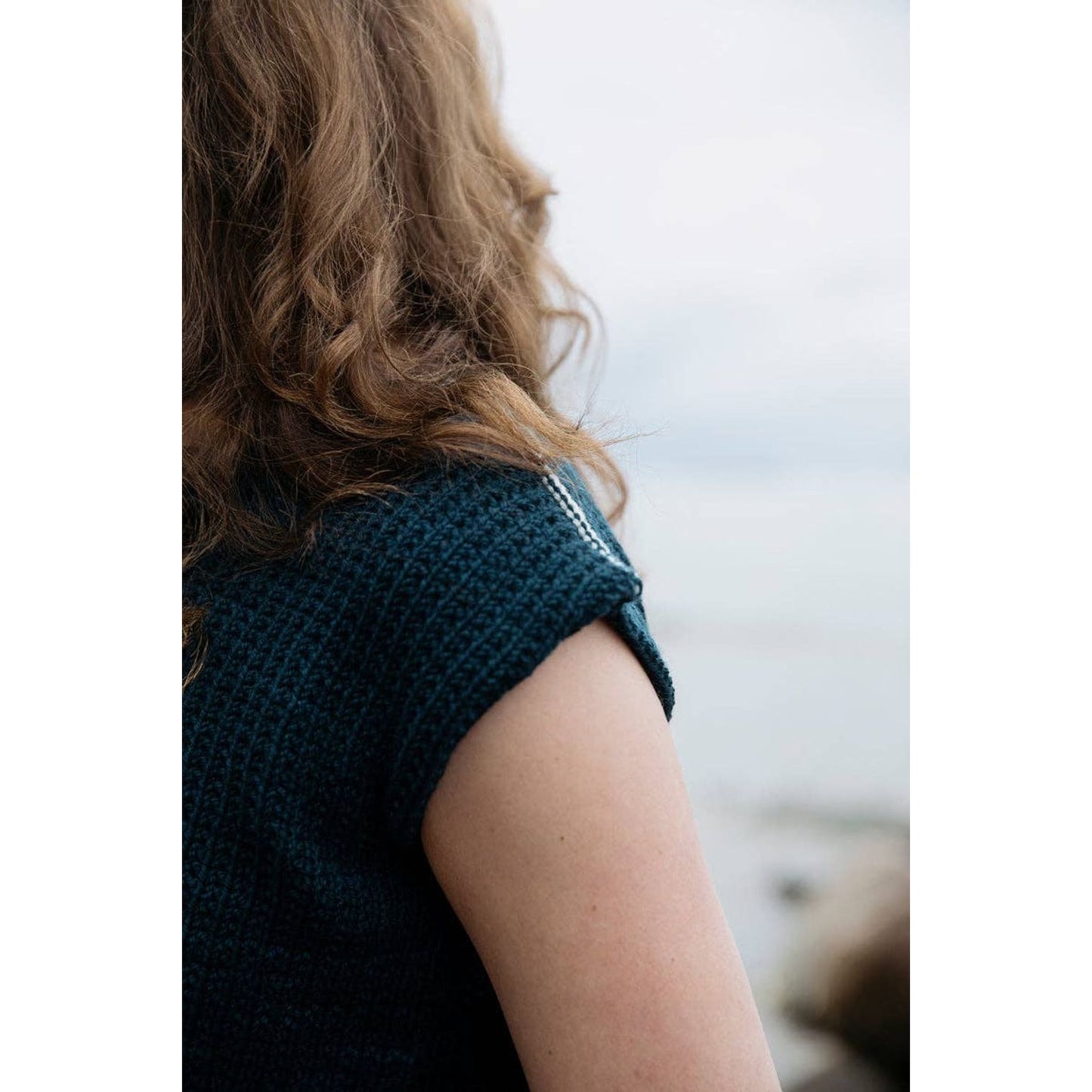 Close-up of a woman's shoulder in a knitted garment from the Soothing Stitches knitting book
