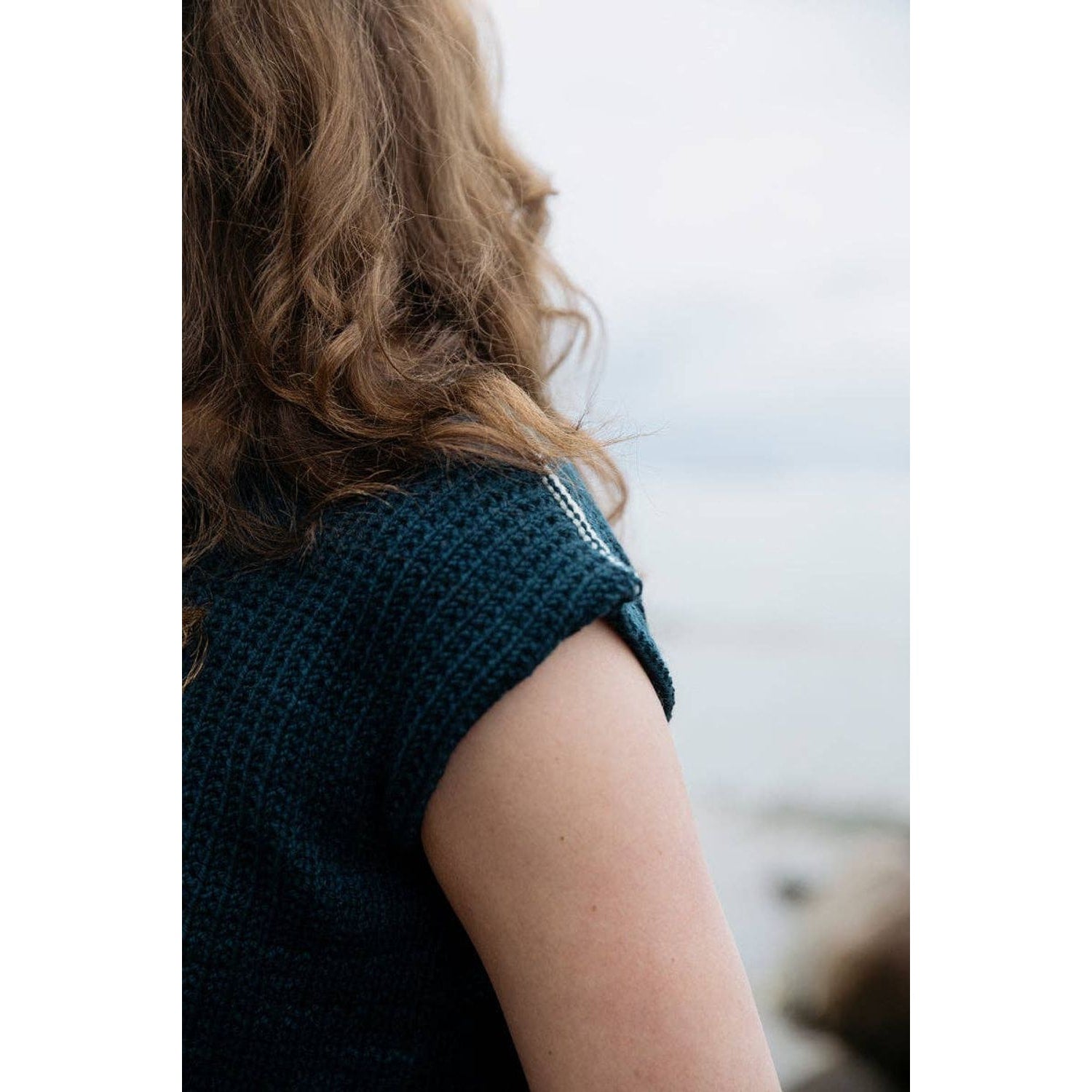 Close-up of a woman's shoulder in a knitted garment from the Soothing Stitches knitting book