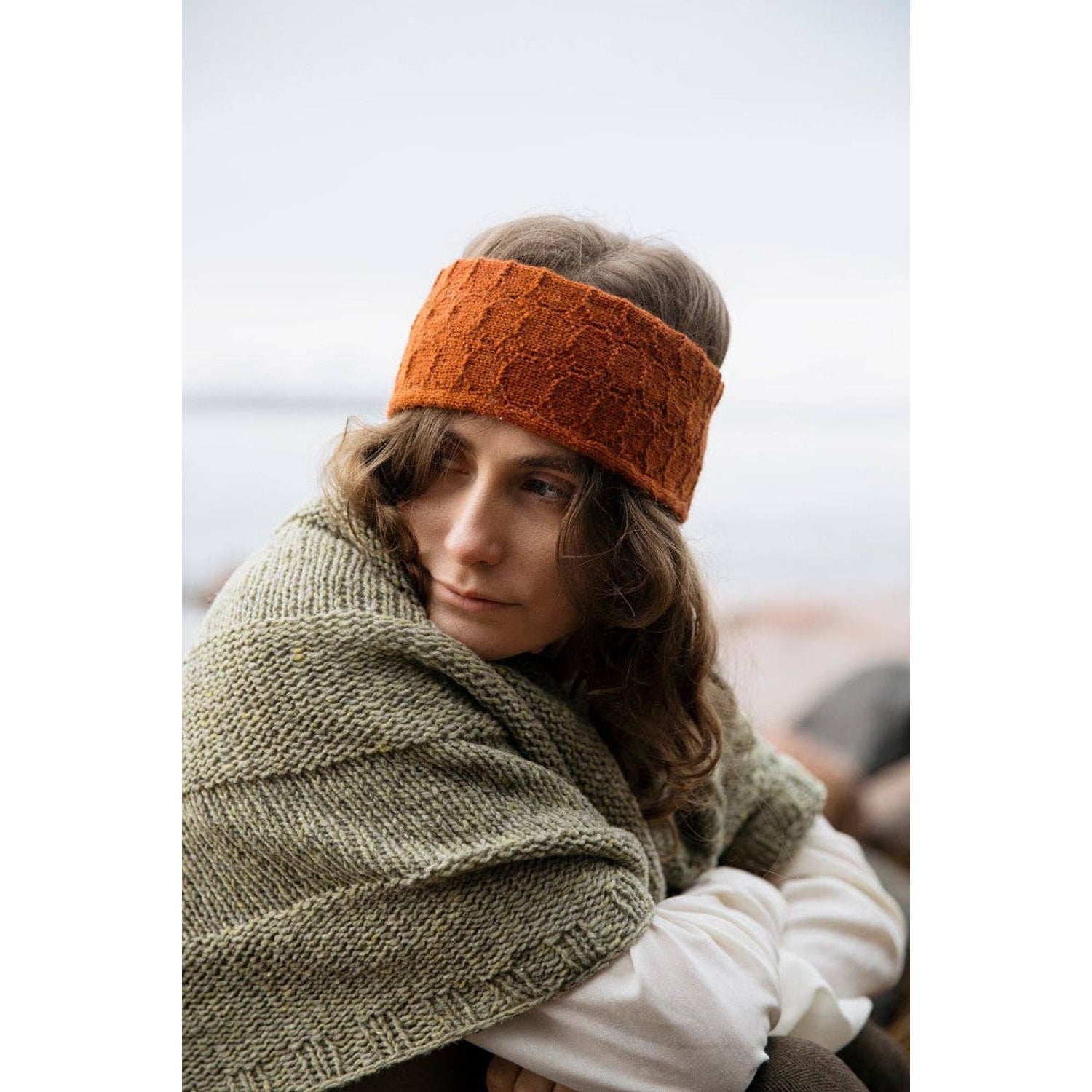 Woman wearing an orange headband and green shawl, inspired by Soothing Stitches knitting book