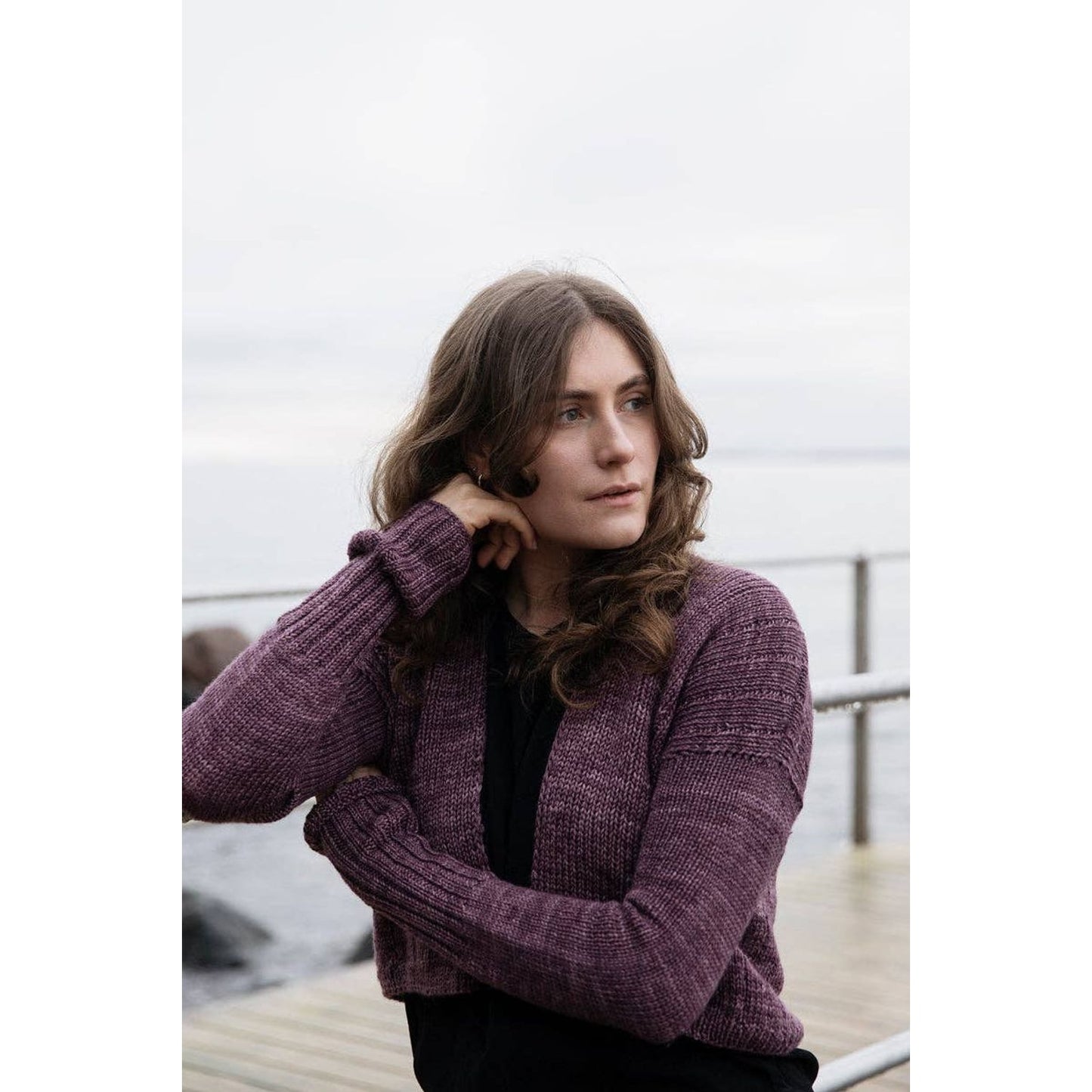 Model wearing a cozy cardigan design from Soothing Stitches knitting book by Laine Publishing