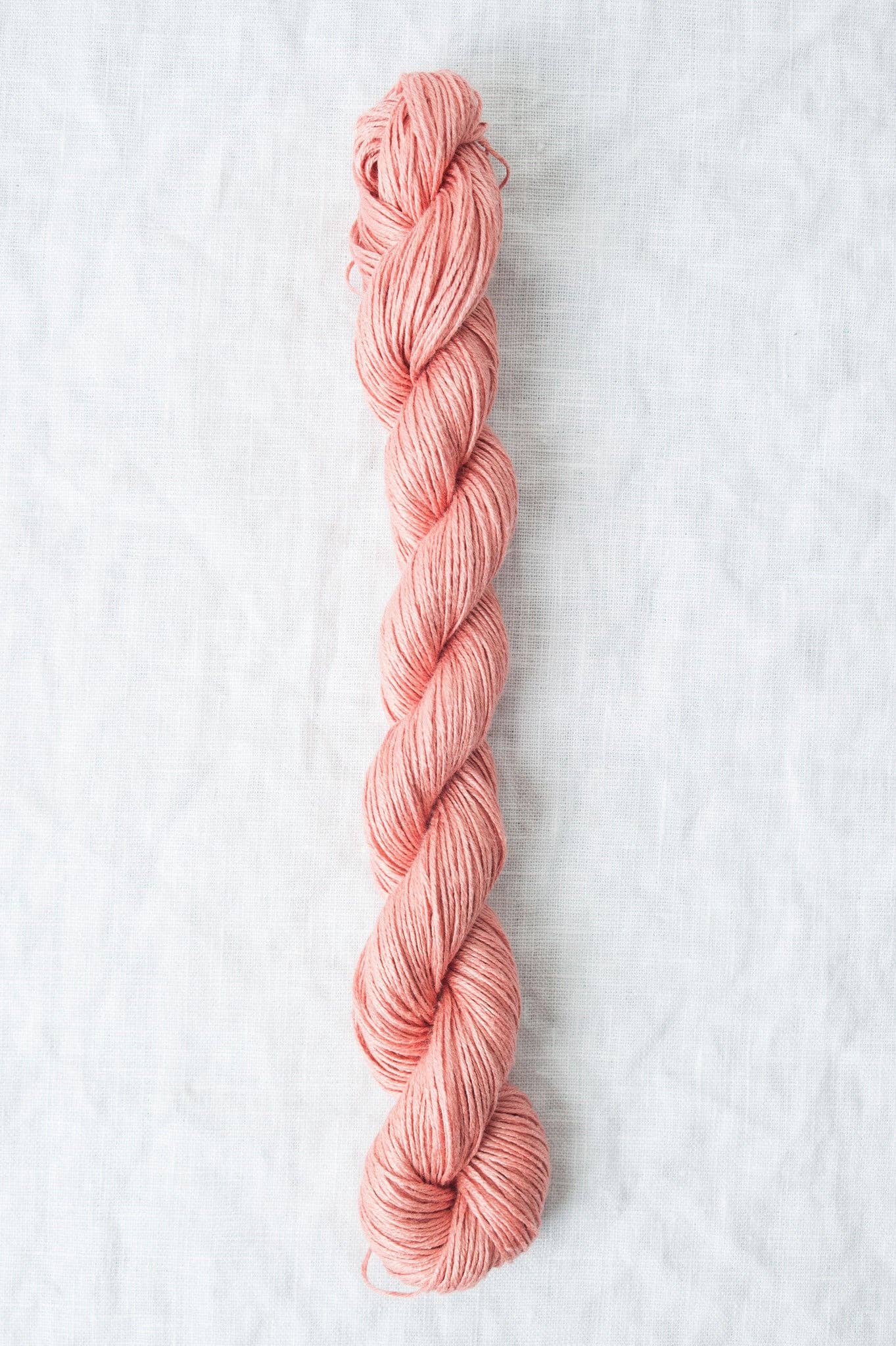 Skein of Sparrow organic linen yarn in soft pink, perfect for knitting and crocheting projects