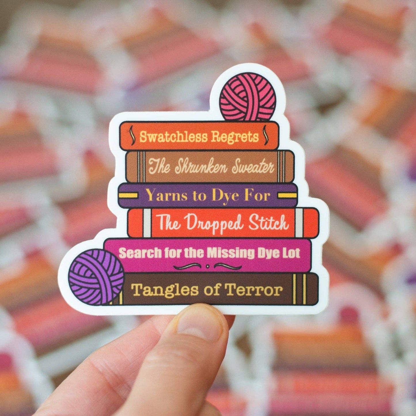 Colorful Camp Stitchwood sticker featuring humorous knitting-themed book titles and yarn balls
