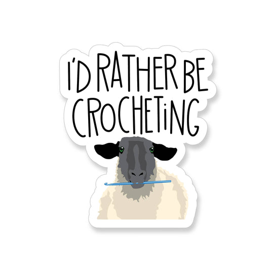 I'd rather be crocheting sticker. Showing a sheep holding a blue crochet hook with bold hand lettered text