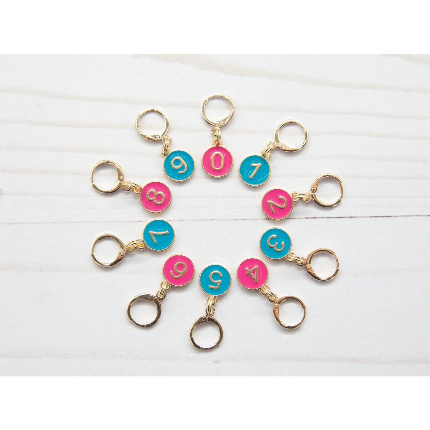 Colorful stitch markers for crocheting in pink and blue with numbered designs