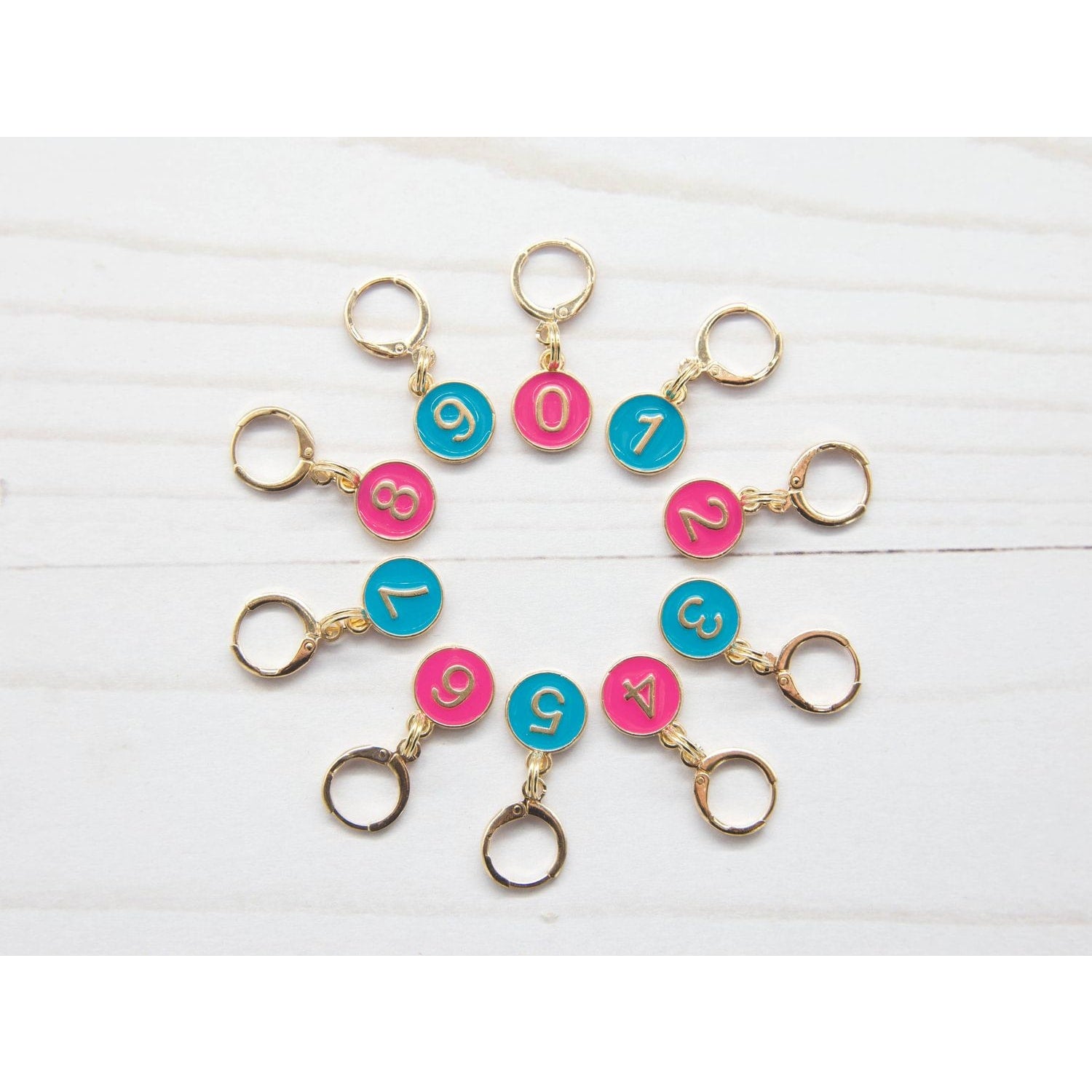 Colorful stitch markers for crocheting in pink and blue with numbered designs