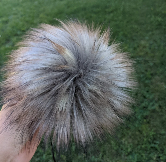 Fluffy stormy grey pom pom for crochet hats in a natural outdoor setting