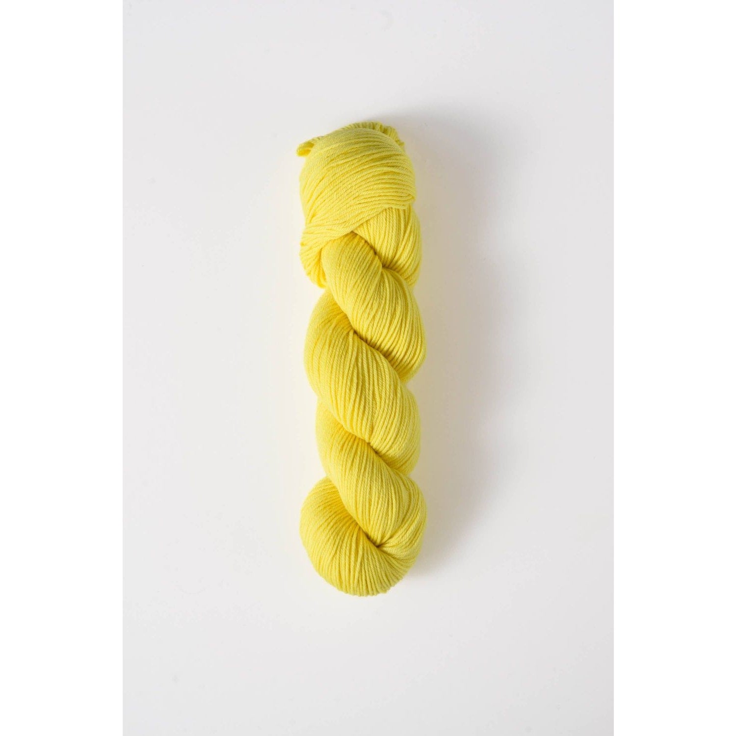Yellow skein of Quince and Co superwash merino fingering yarn for knitting and crochet projects