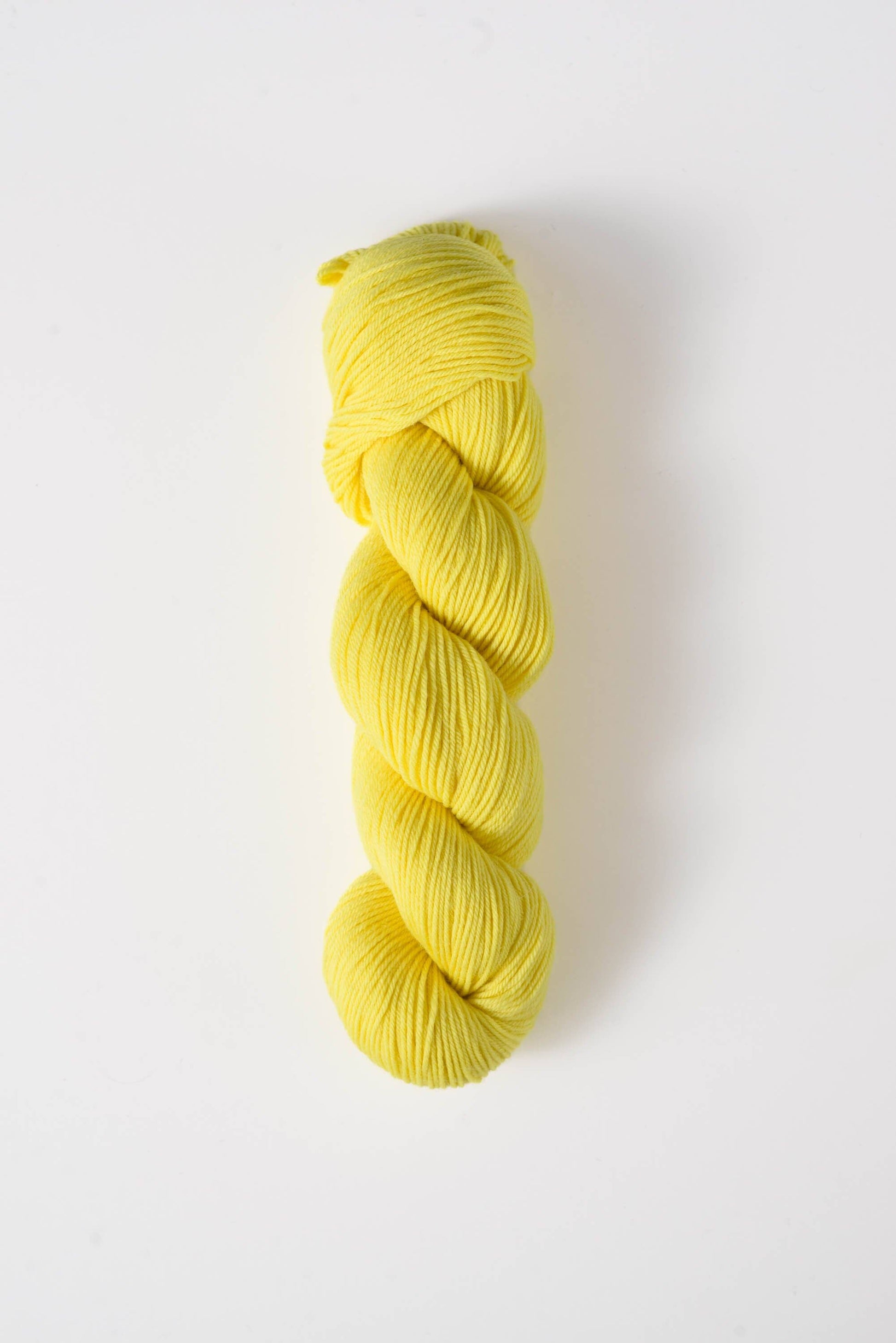 Yellow skein of Quince and Co superwash merino fingering yarn for knitting and crochet projects