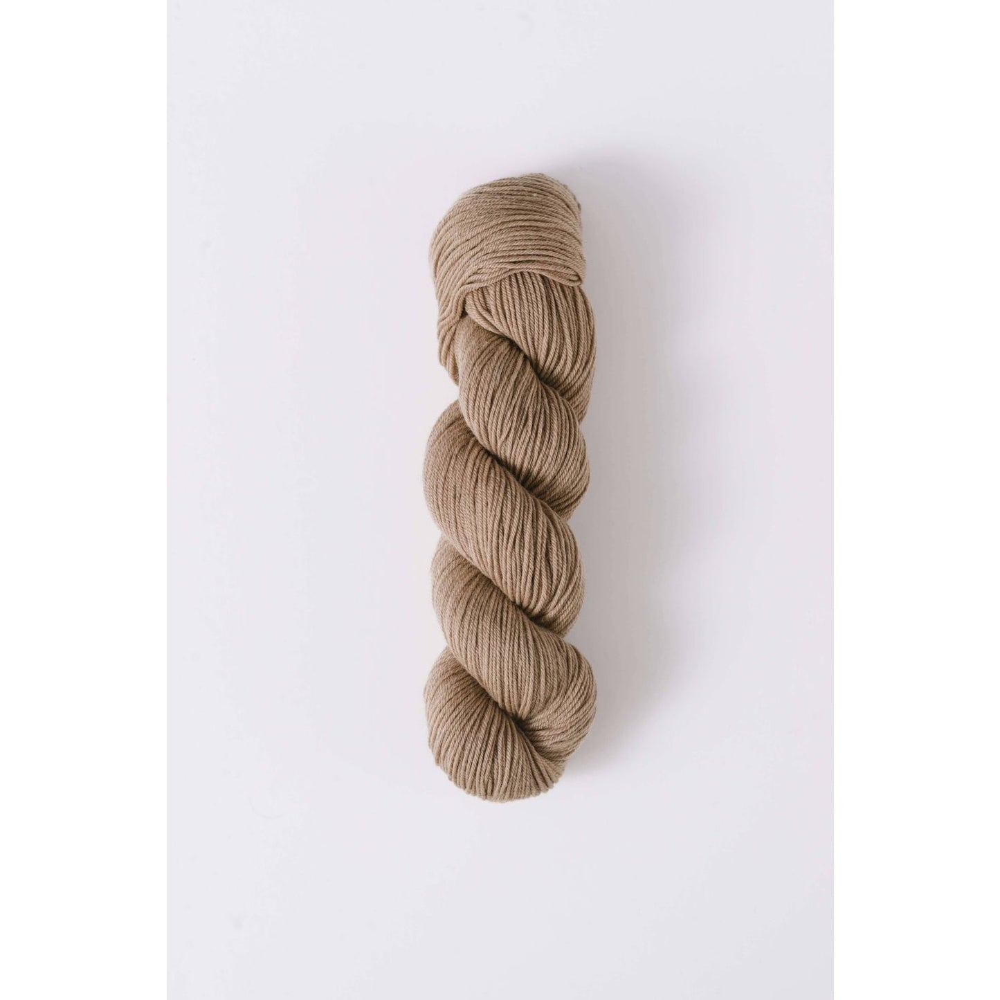 Quince & Co. superwash merino fingering yarn in a natural beige color skein