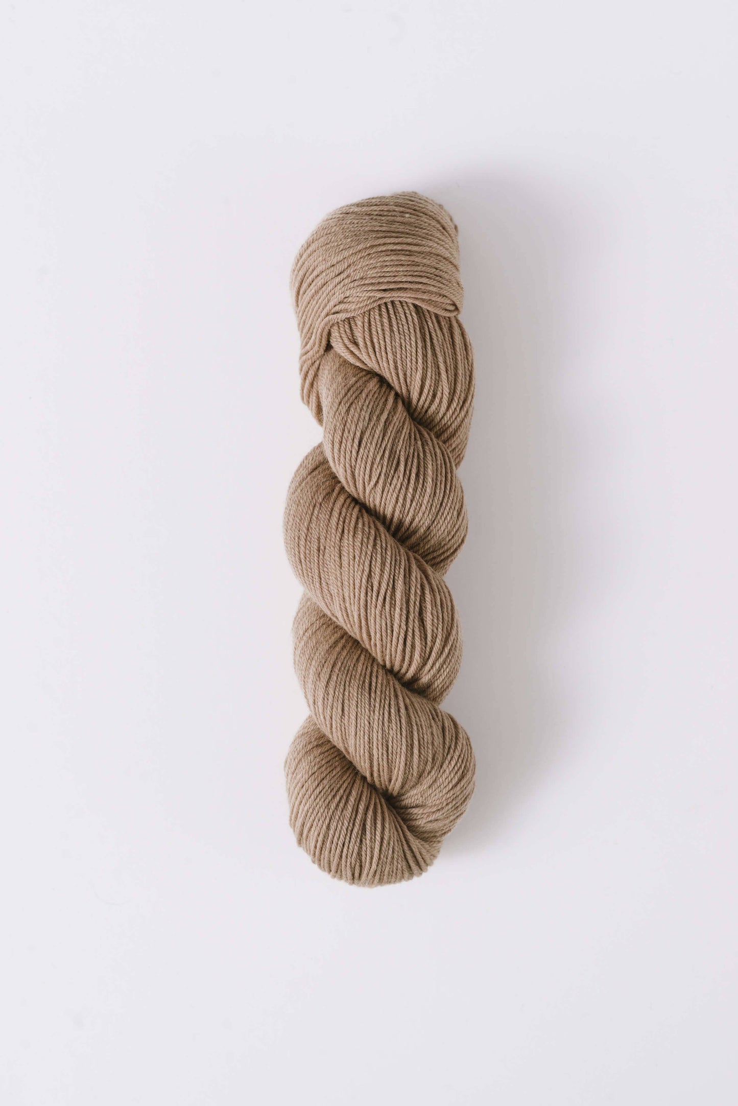 Quince & Co. superwash merino fingering yarn in a natural beige color skein