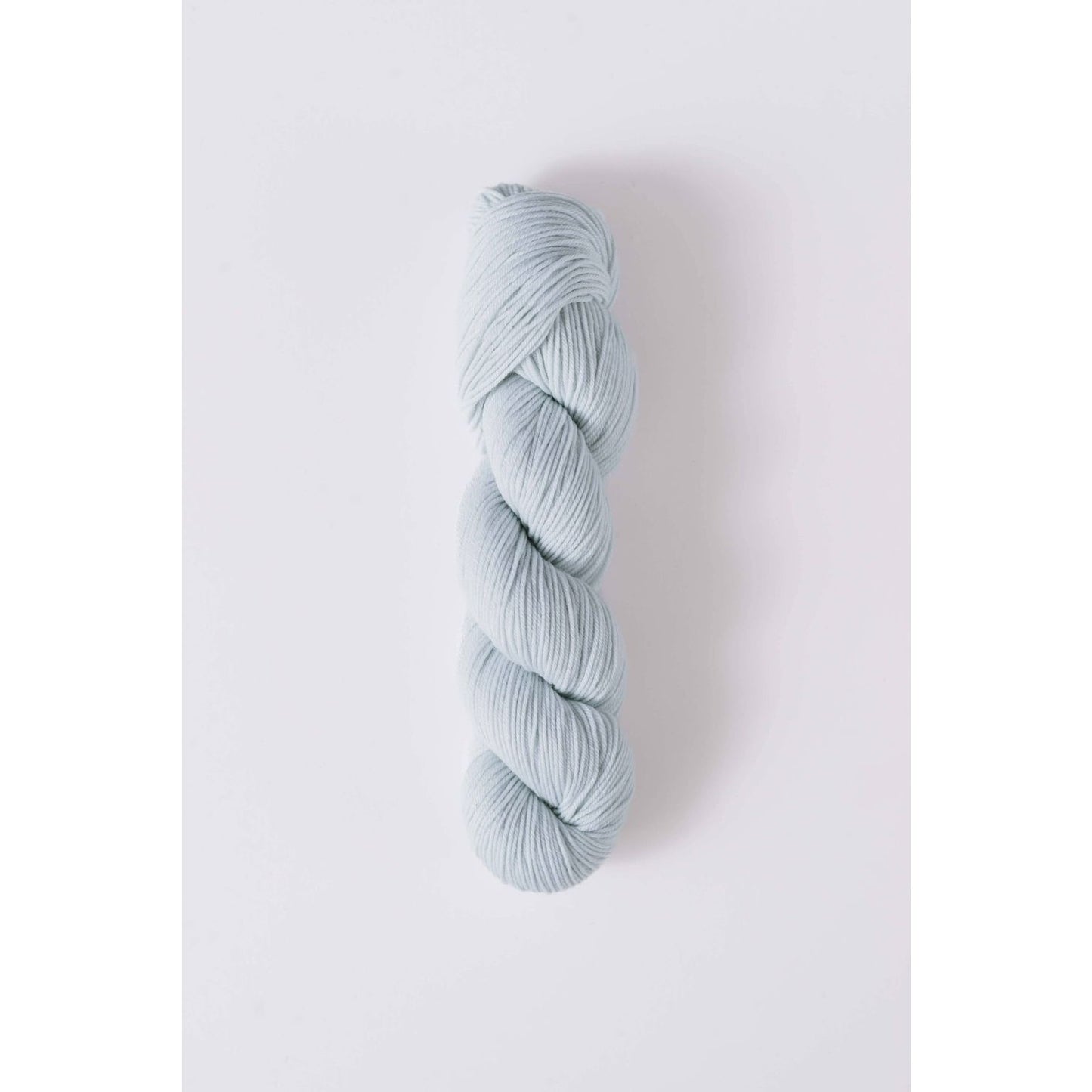 Quince & Co superwash merino fingering yarn in soft pale blue twisted skein