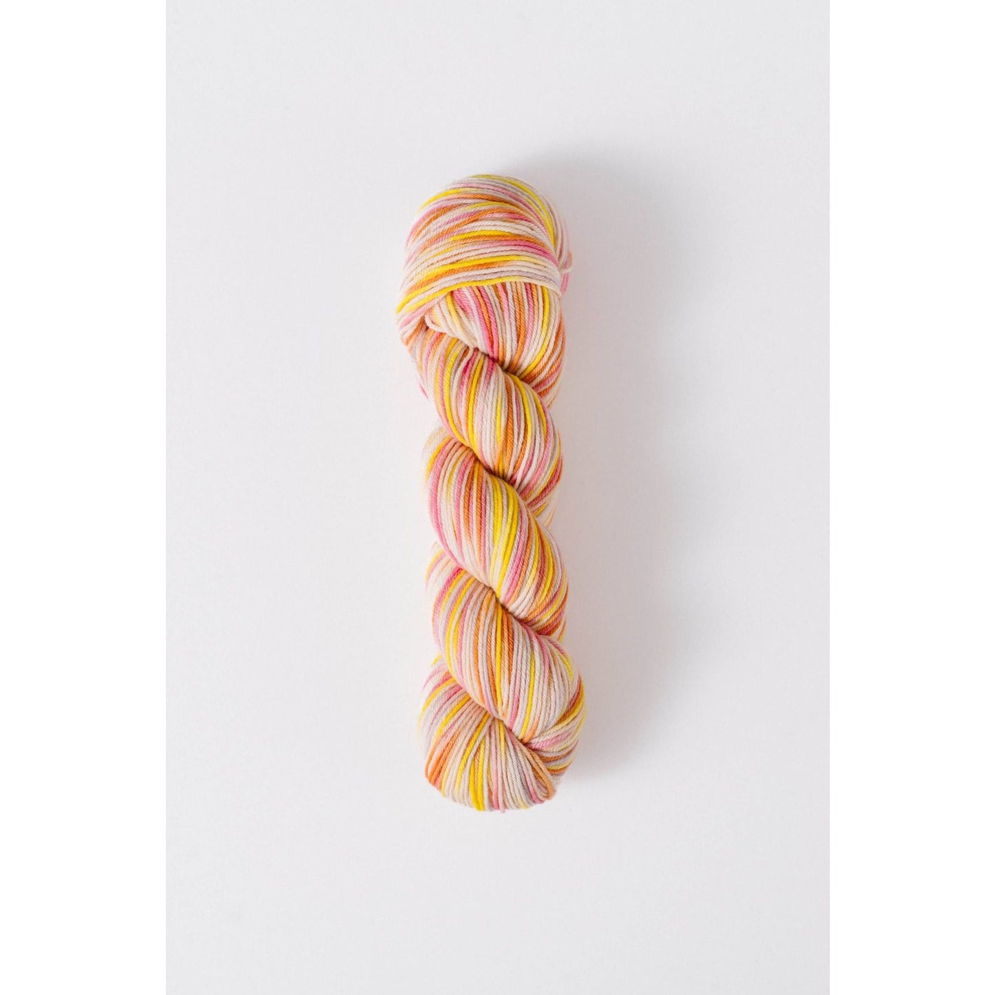 Quince & Co superwash merino fingering yarn in variegated pink yellow and orange colors