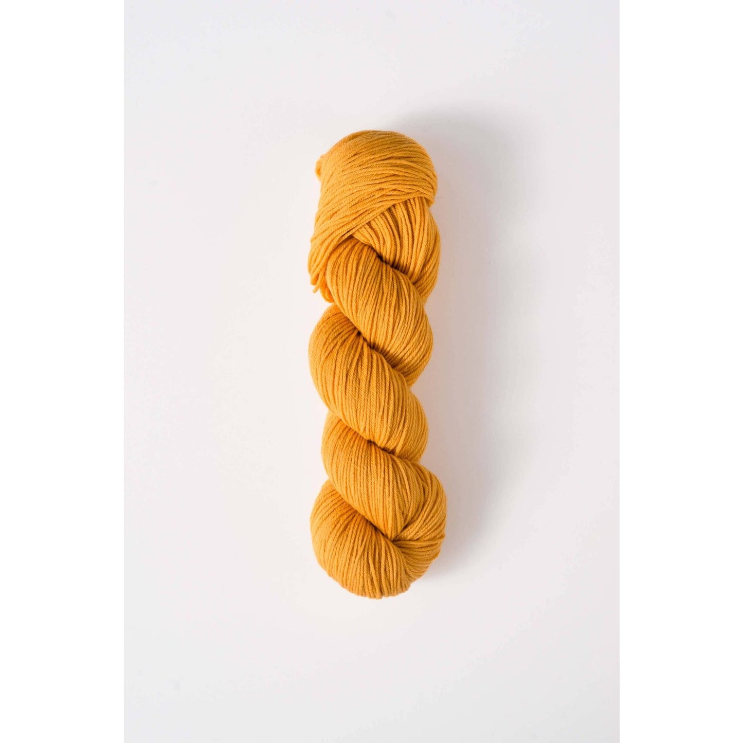 Quince & Co. superwash merino fingering yarn in a vibrant mustard yellow color skein