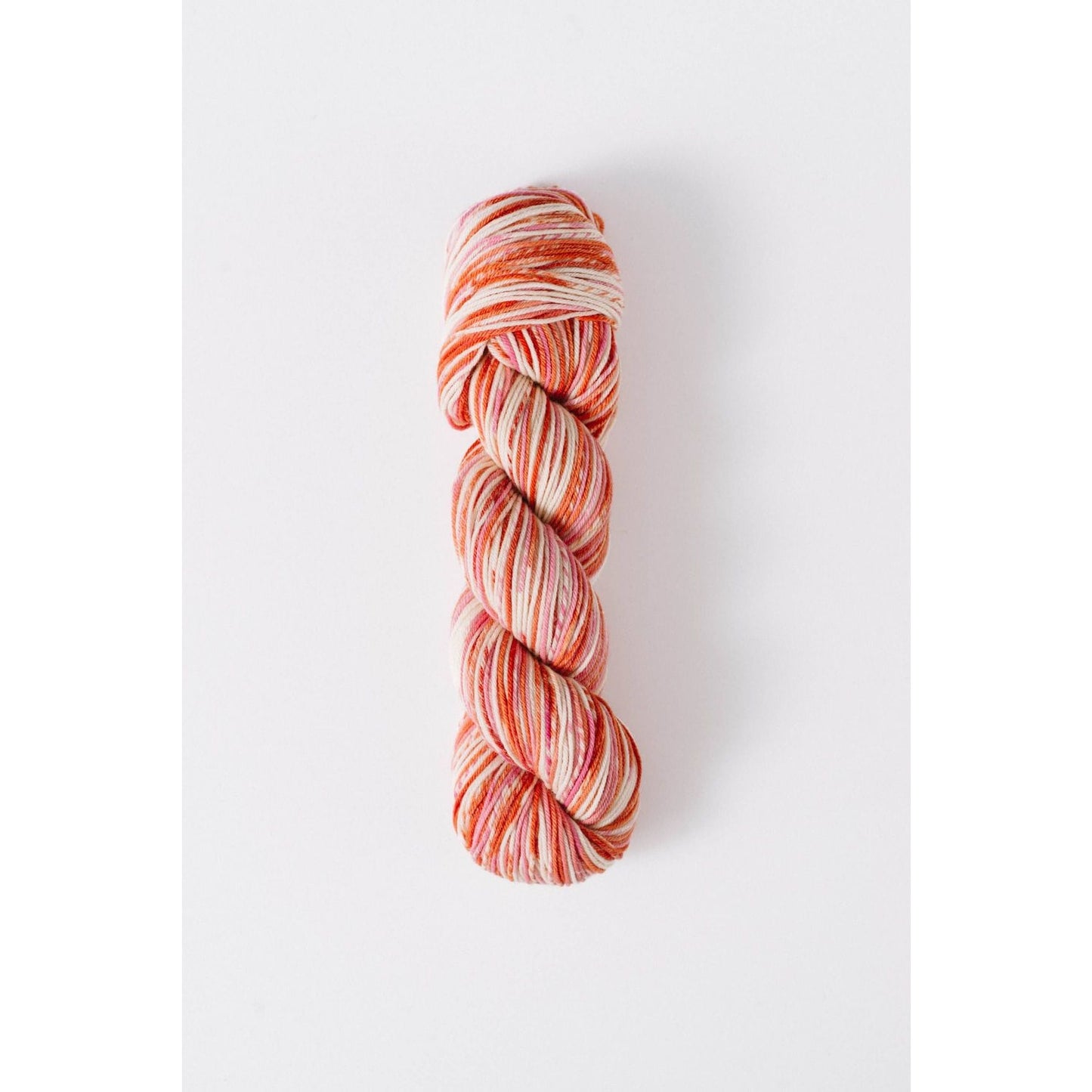 Quince and Co superwash merino fingering yarn in a variegated orange and cream colorway