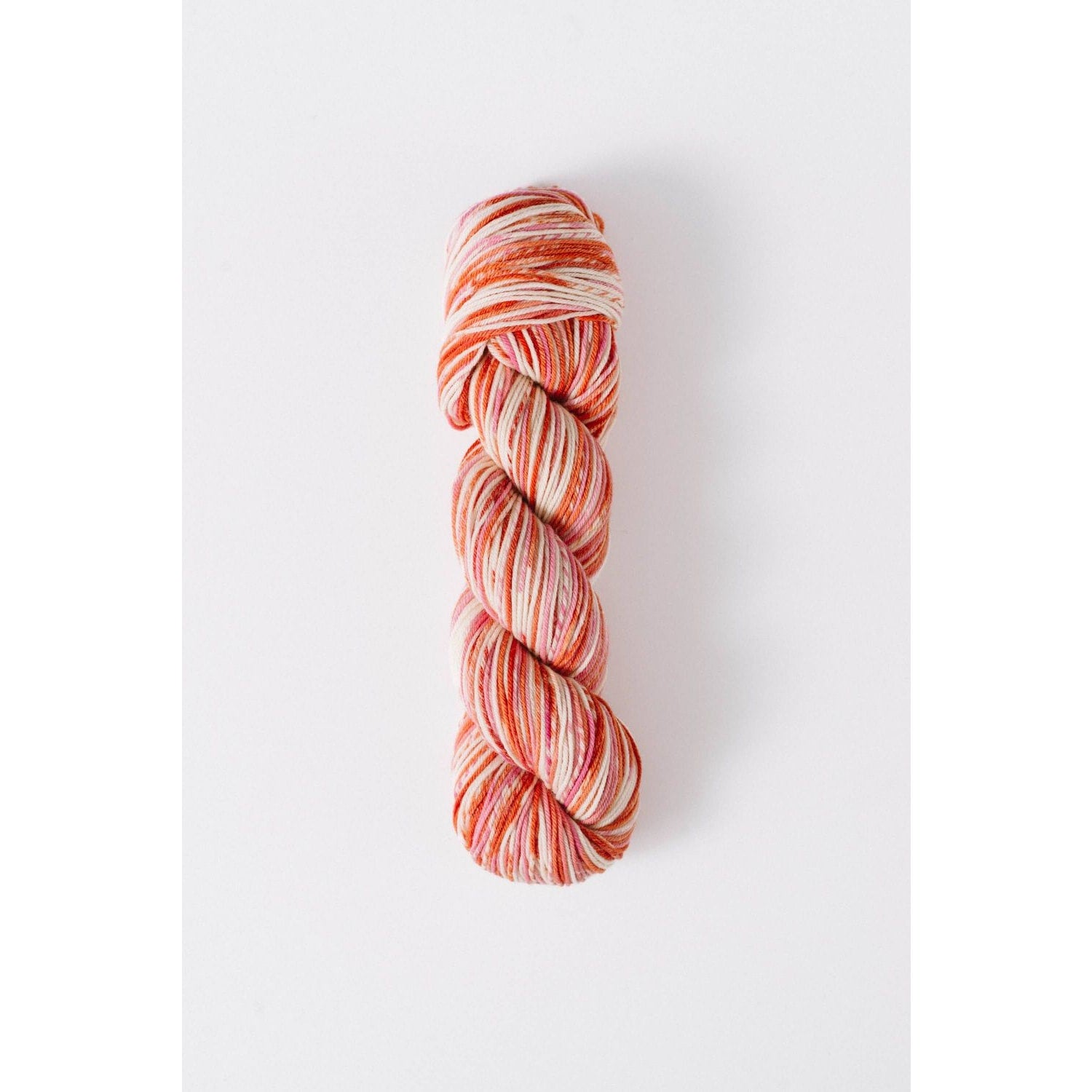 Quince and Co superwash merino fingering yarn in a variegated orange and cream colorway