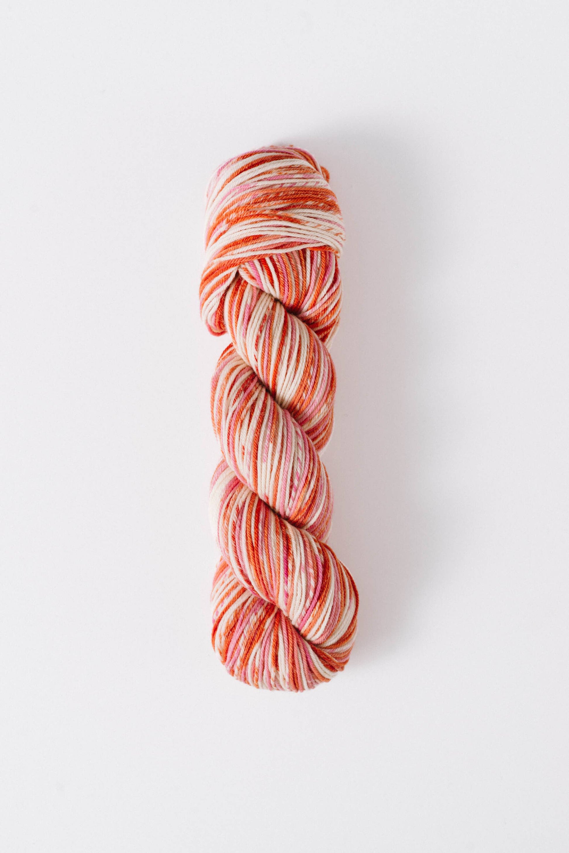 Quince and Co superwash merino fingering yarn in a variegated orange and cream colorway