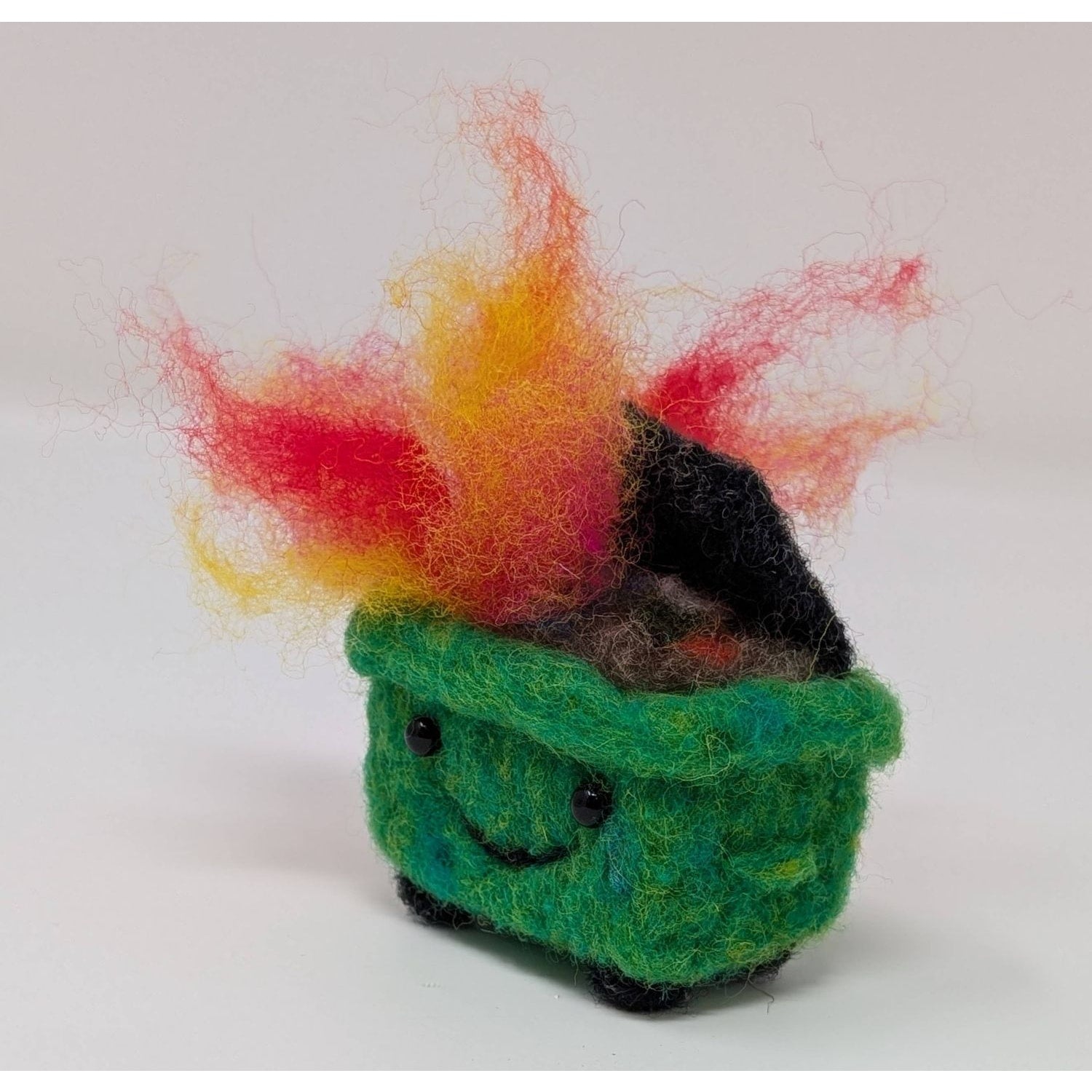 Cute felted green trash can with colorful flames made using needle felting needles
