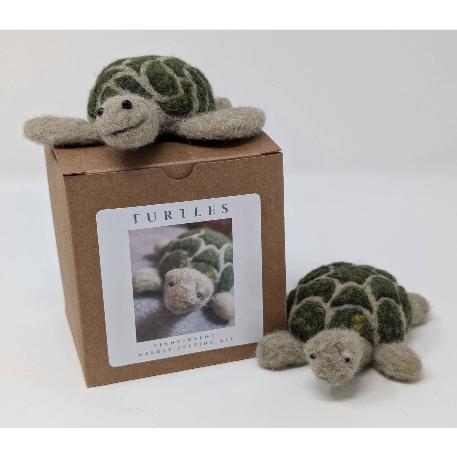 Two needle felted turtle figurines with a crafting kit box for needle felting needles