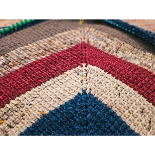 Close-up of a multicolored piece showcasing tunisian crochet techniques and textures