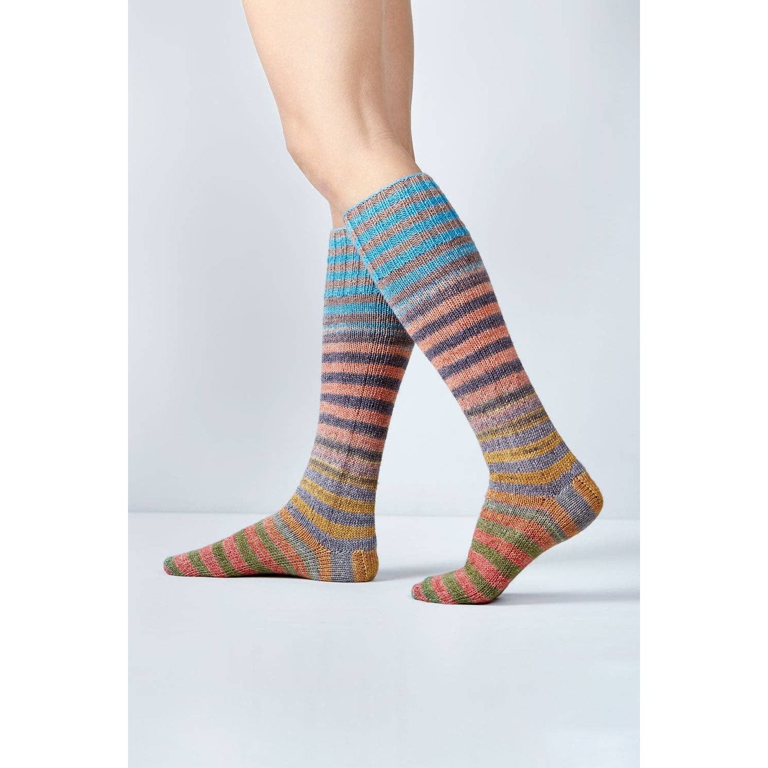 Colorful knitted socks made with Urth Yarns Uneek Sock Kit for Knitting, showcasing vibrant stripes