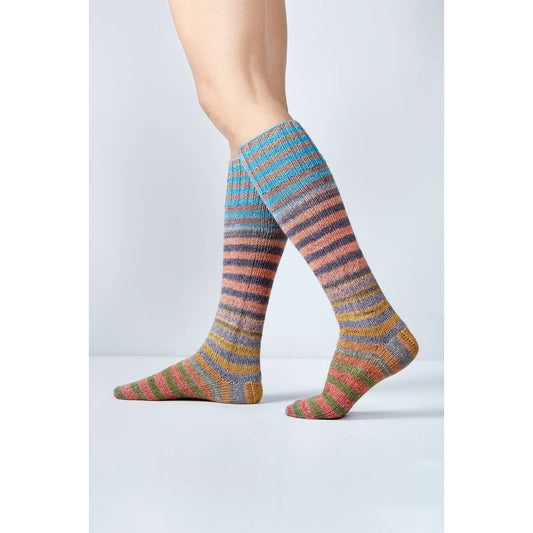 Colorful knitted socks made with Urth Yarns Uneek Sock Kit for Knitting, showcasing vibrant stripes