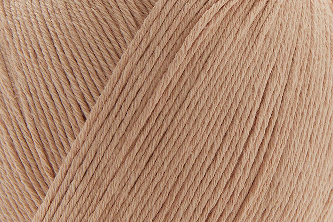 Close-up of Universal Yarn Bamboo Pop in soft peach color, perfect for knitting or crocheting projects