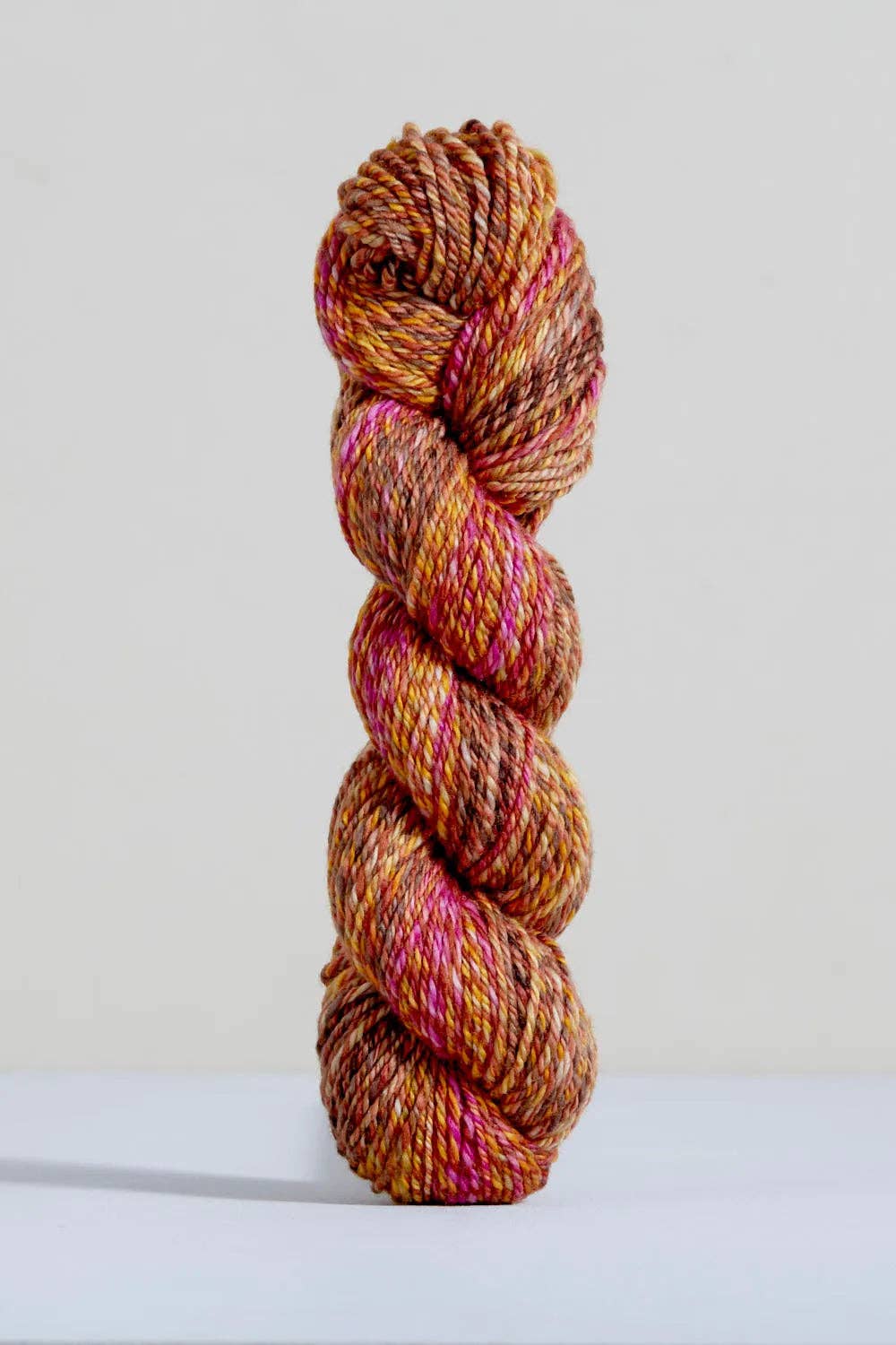 Urth Yarns Spiral Grain Light Worsted Teak with rich orange and pink tones for knitting projects