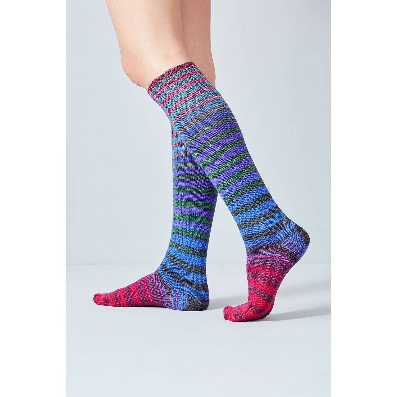 Colorful knee-high socks made from Urth Yarns Uneek Sock Kit featuring vibrant stripes