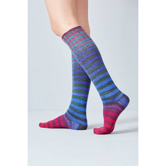 Colorful knee-high socks made from Urth Yarns Uneek Sock Kit featuring vibrant stripes