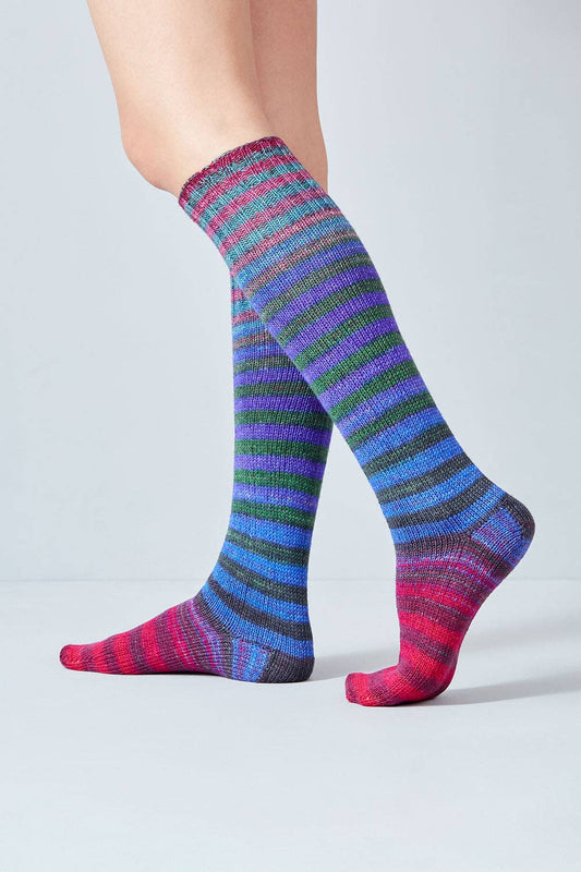 Colorful knee-high socks made from Urth Yarns Uneek Sock Kit featuring vibrant stripes